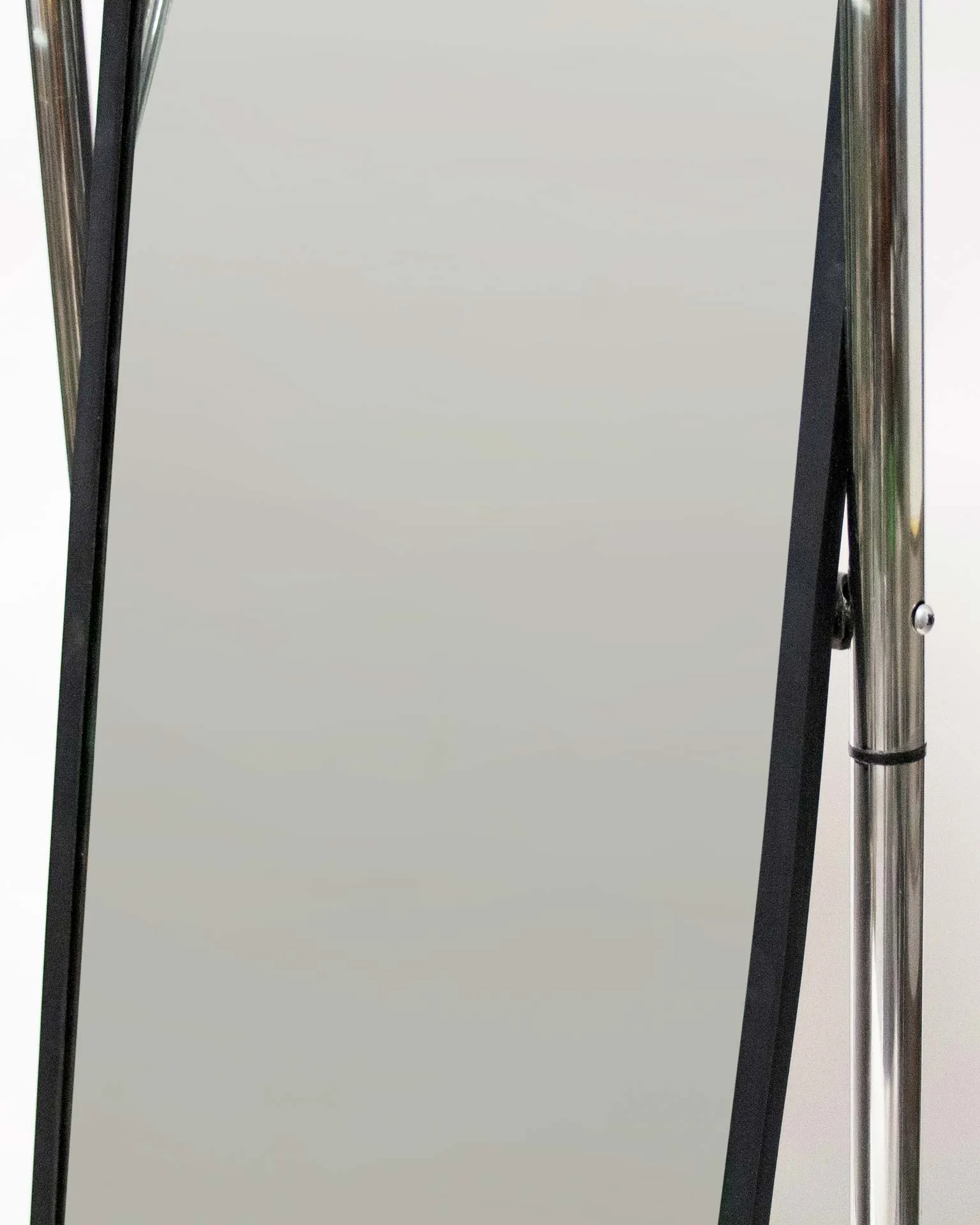 A mirror created by Jannis Schäfer Studio, made from upcycled theft detectors and a reclaimed marble tabletop. The design features a tall, narrow, swingable mirror framed in a chrome structure with a marble base. This object, titled 'Stealing Beauty,' is part of a series of recycled and transformed designs.