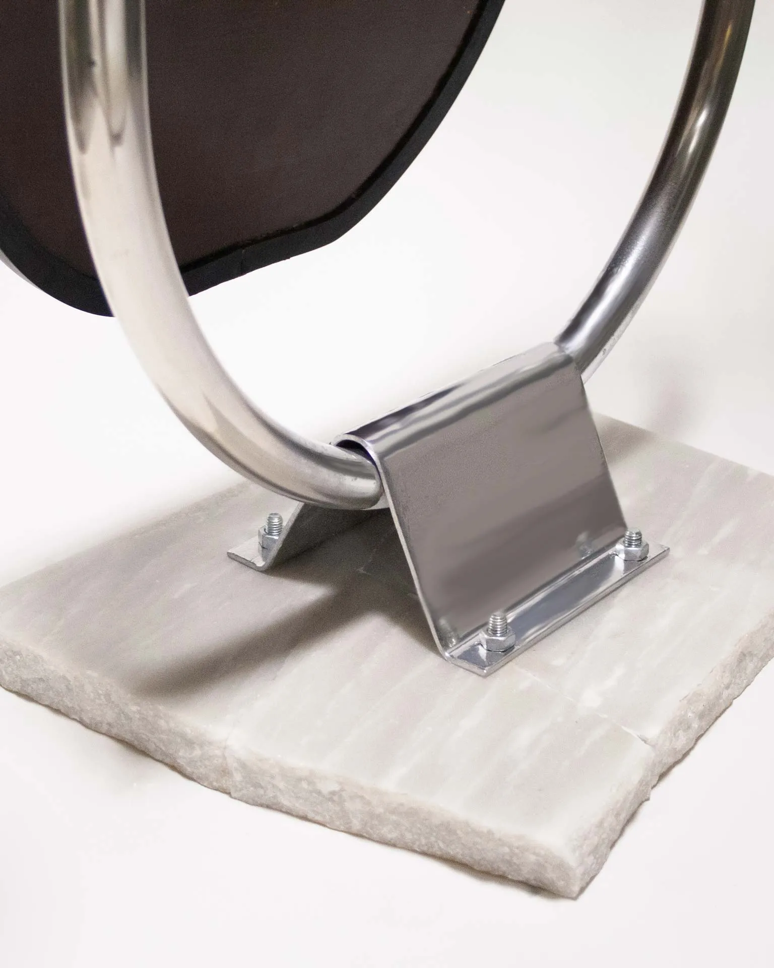 A mirror created by Jannis Schäfer Studio, made from upcycled theft detectors and a reclaimed marble tabletop. The design features a tall, narrow, swingable mirror framed in a chrome structure with a marble base. This object, titled 'Stealing Beauty,' is part of a series of recycled and transformed designs.