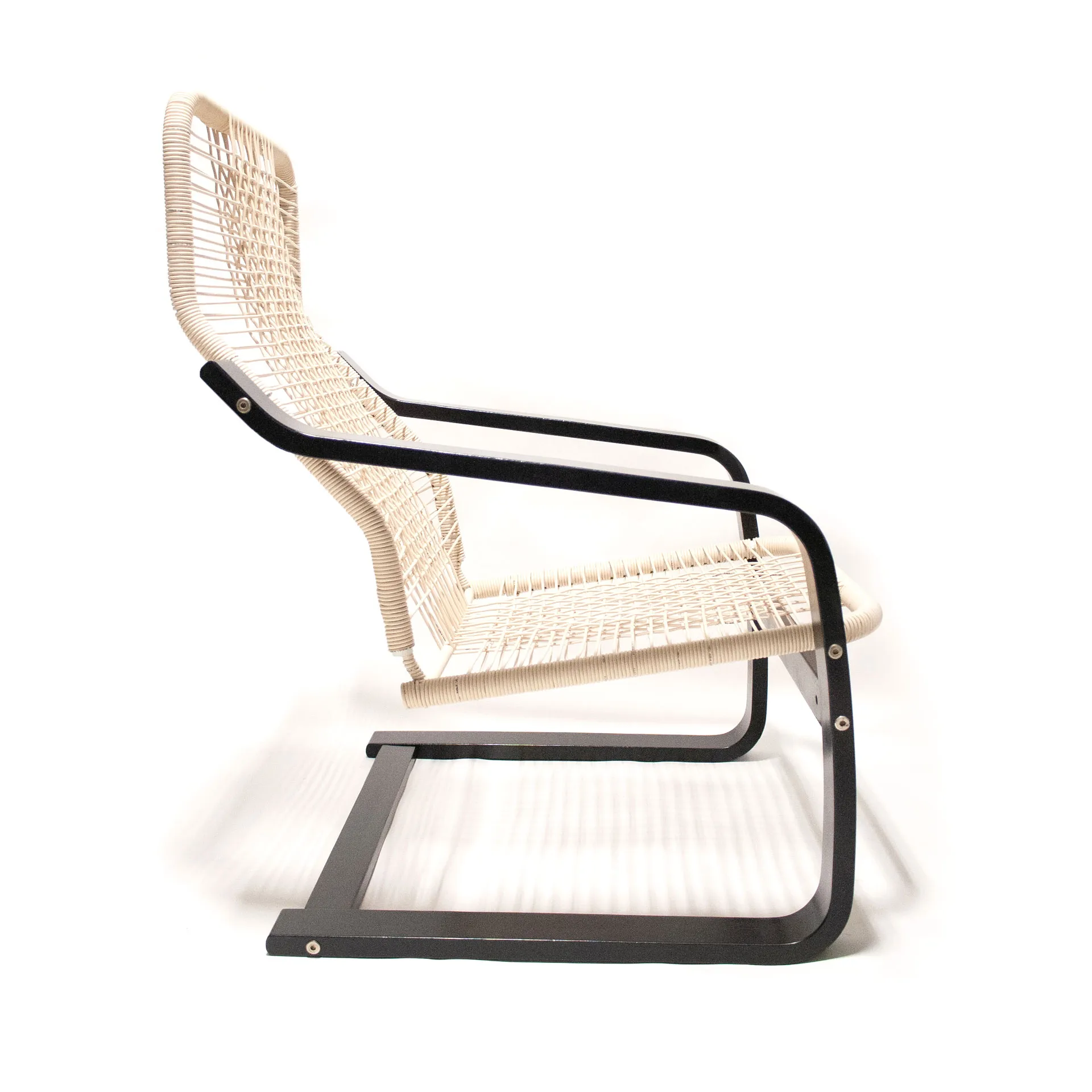 The 'Telefonica Lounge Chair' created by Jannis Schäfer Studio, made from reclaimed telephone cables woven into a supportive seat and backrest. The chair features a sleek black frame with curved armrests and legs. This upcycled, recycled, and transformed piece is part of a series of derivative designs.