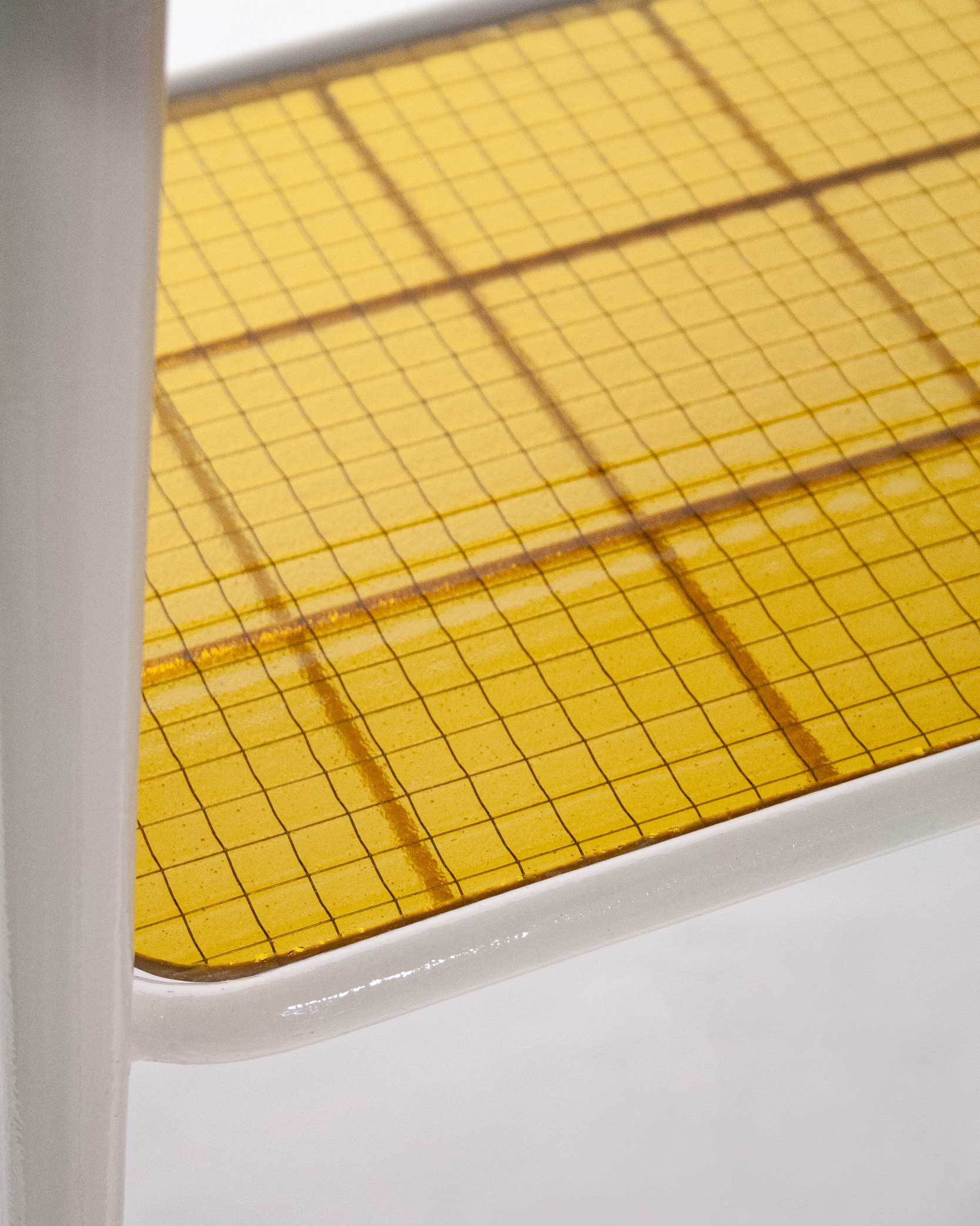 "The 'Lithic Side Table,' created by Jannis Schäfer Studio, is made from reclaimed black marble (nero Marquina) and wired glass, set on an unwanted table frame. This upcycled, recycled, and transformed piece is part of a series of derivative designs. The table features a black marble top with white veining and a yellow wired glass shelf beneath."